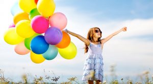 Young girl with a bunch of balloons